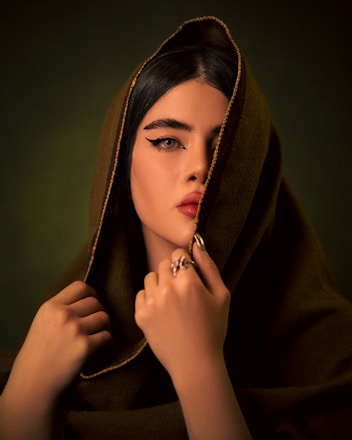 A woman wearing a brown hoodie with a ring on her finger