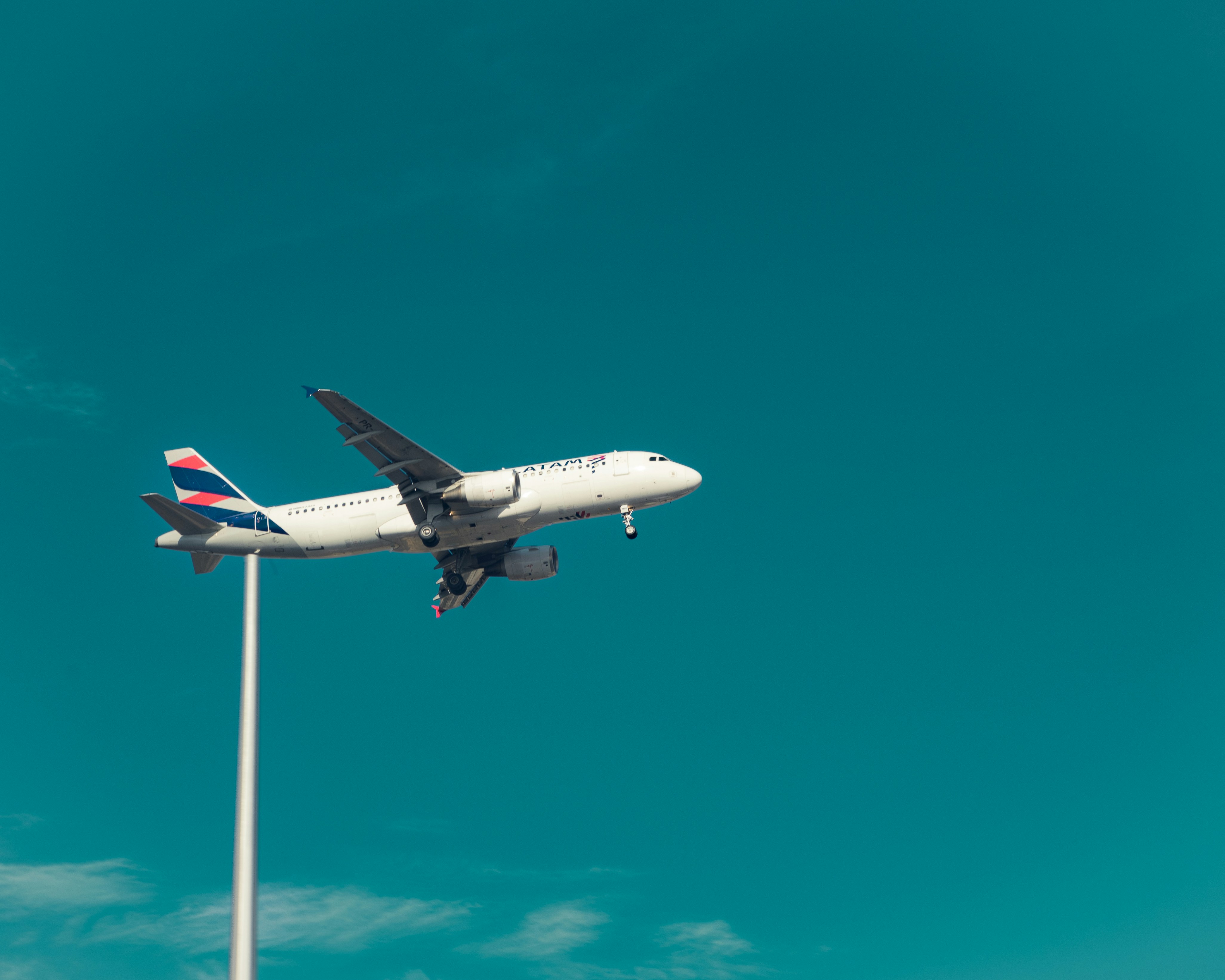 An airplane flying in the sky over a parking lot, 