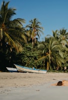A woman laying on a beach next to a boat