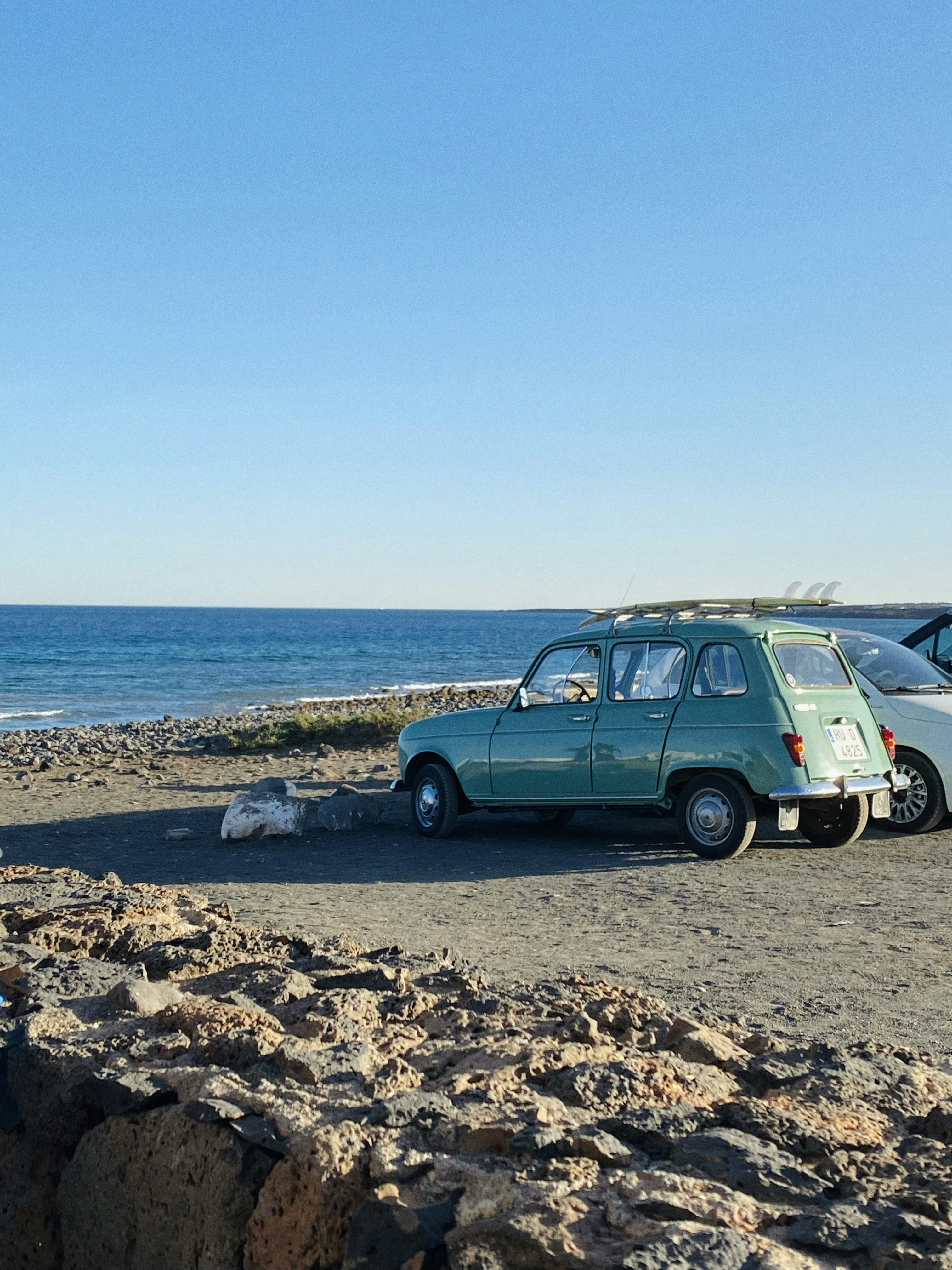 Um par de carros estacionados em cima de uma praia de areia