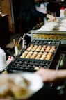 A buffet line of food being prepared for consumption