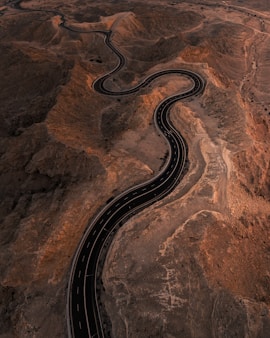 An aerial view of a winding road in the desert