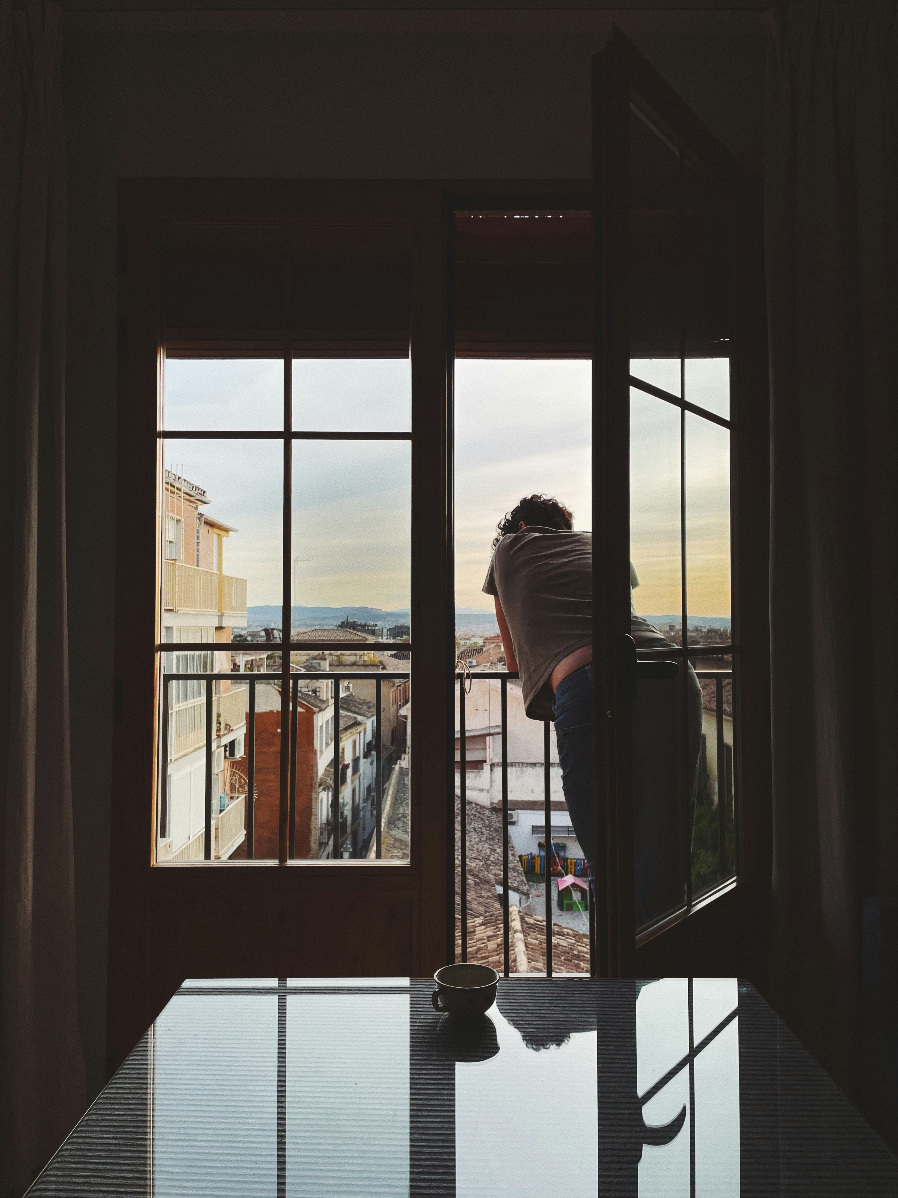 テーブルに座って窓の外を眺めている人