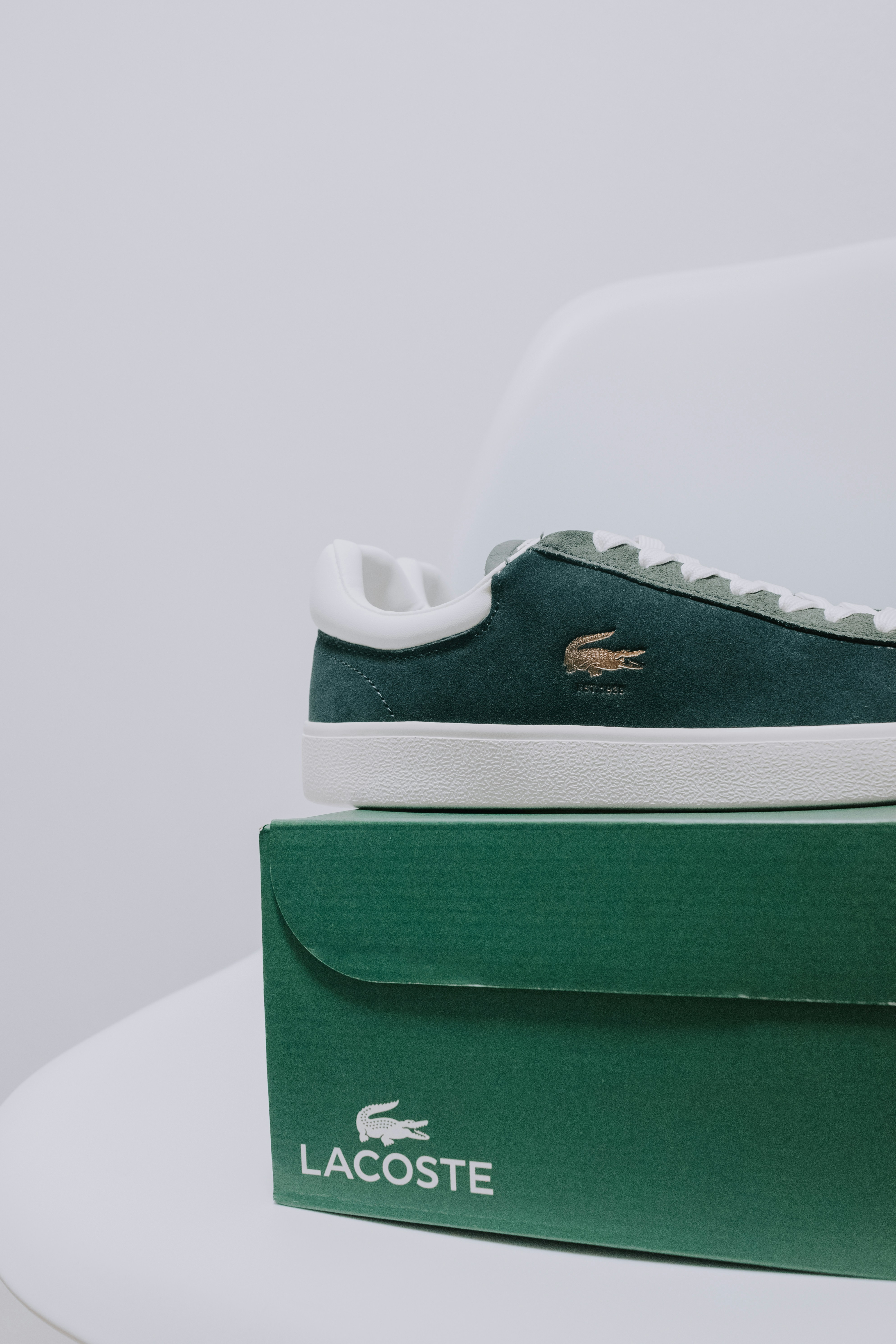 A pair of lacoste shoes sitting on top of a box
