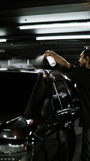 A man standing next to a parked car