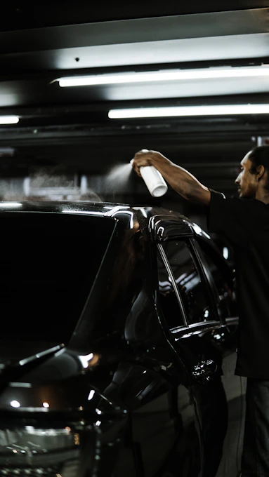 A man standing next to a parked car