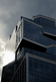 A tall building with lots of windows under a cloudy sky