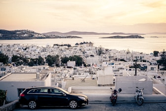 A car parked on the side of a road next to a body of water