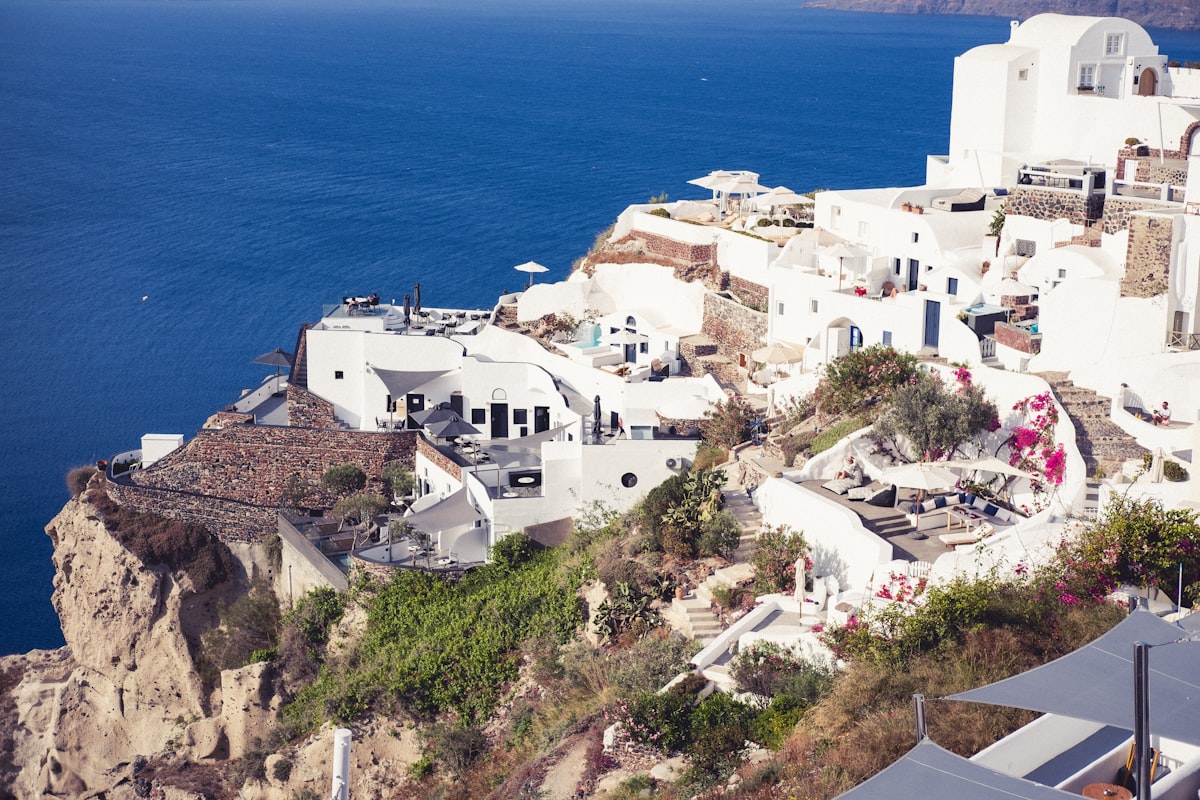 White buildings and blue domes of a Greek Cycladic village against the Aegean Sea