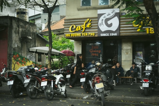A group of motorcycles parked in front of a cafe