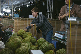 A group of men standing around a pile of fruit