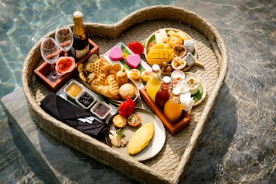 A heart shaped tray filled with food next to a pool