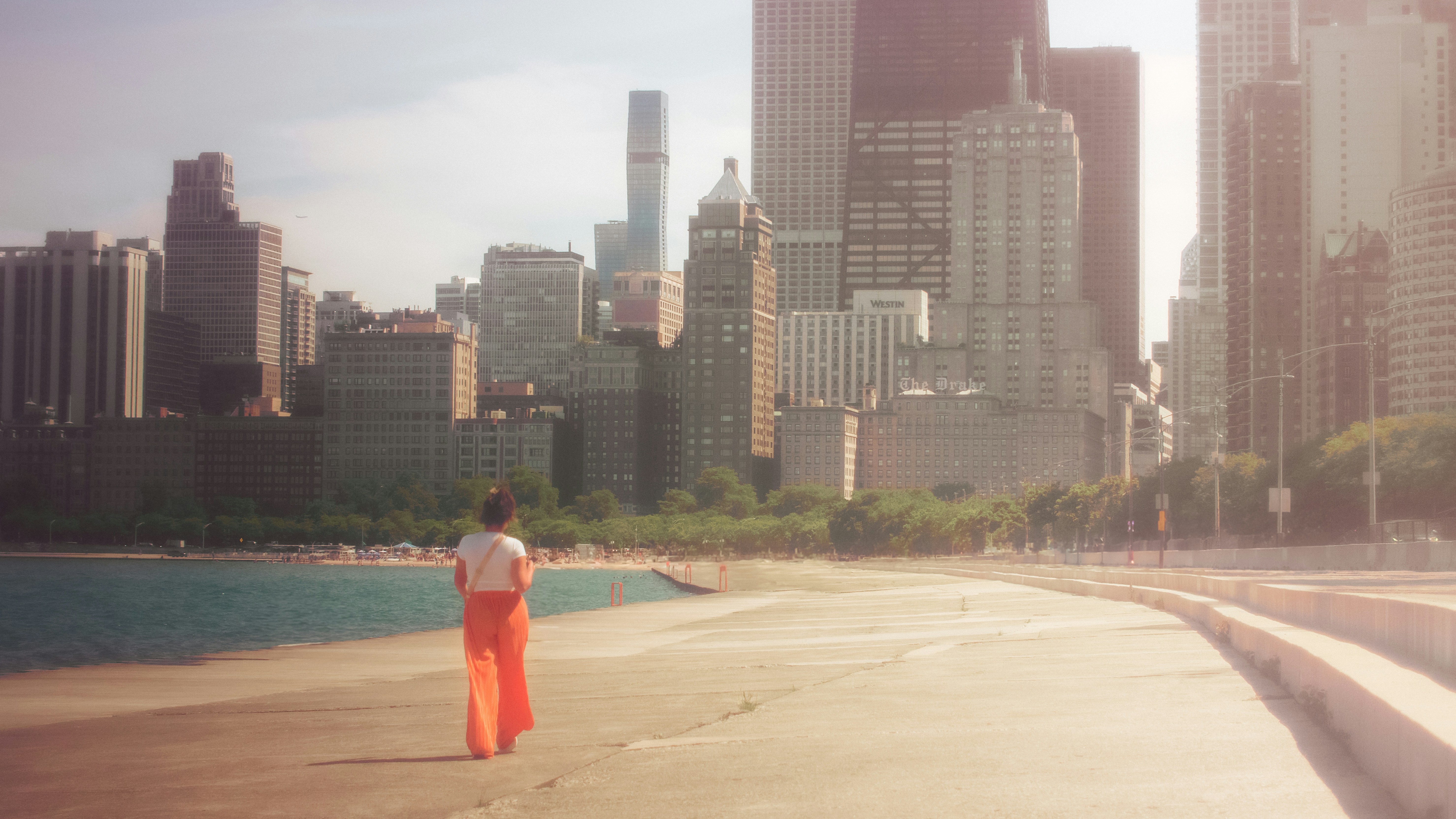 A person standing on a beach in front of a city