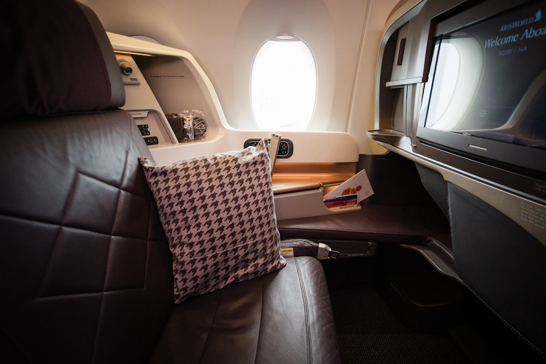 A seat in an airplane with a television on it,