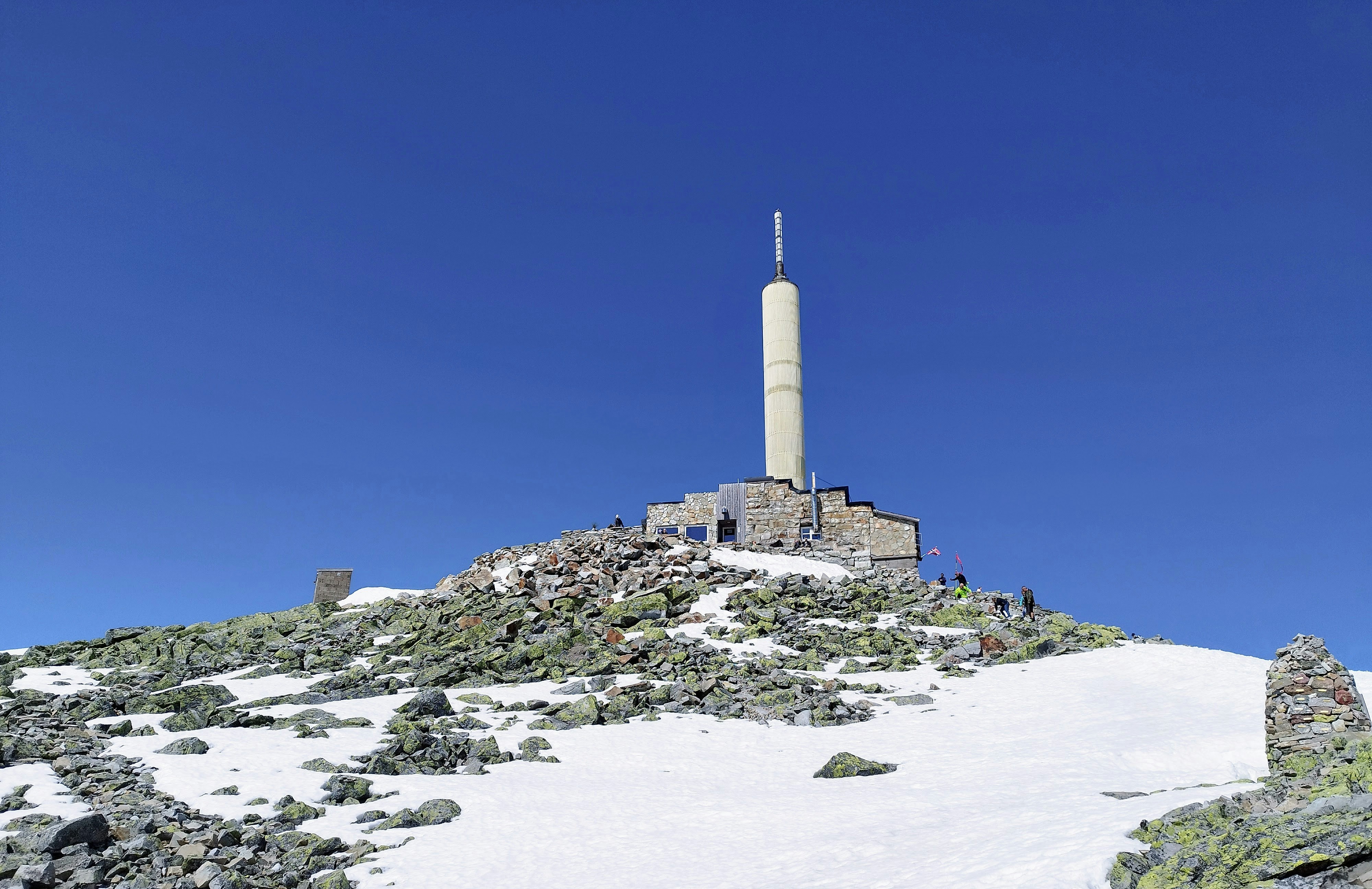 A very tall tower sitting on top of a snow covered hill