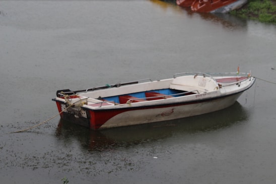 A small boat floating on top of a body of water