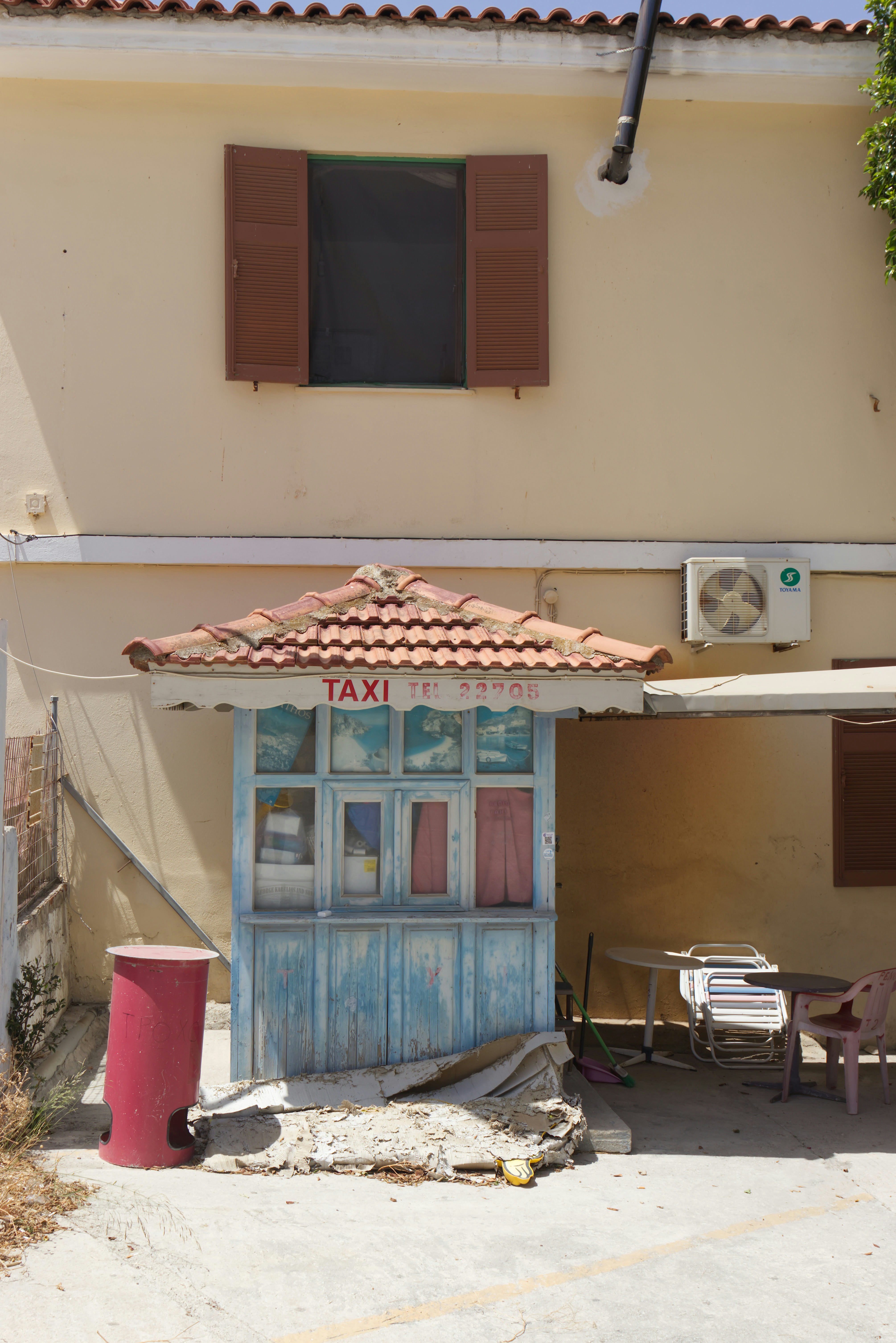 A building with a blue door and a red trash can