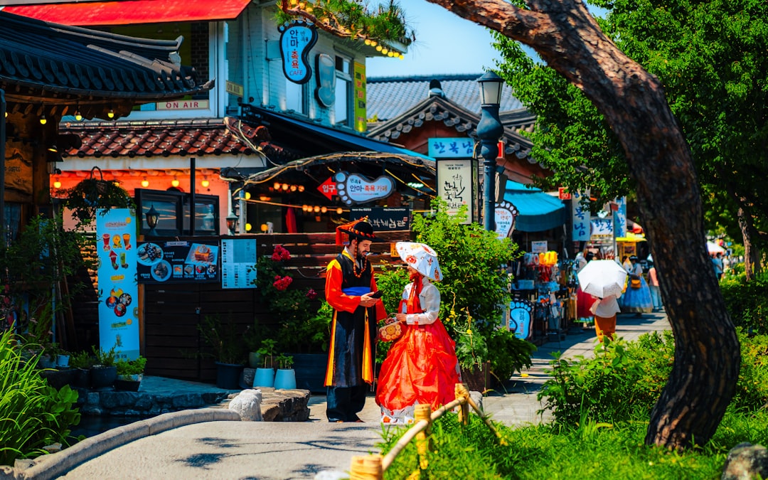 A woman in a red dress walking down a street,