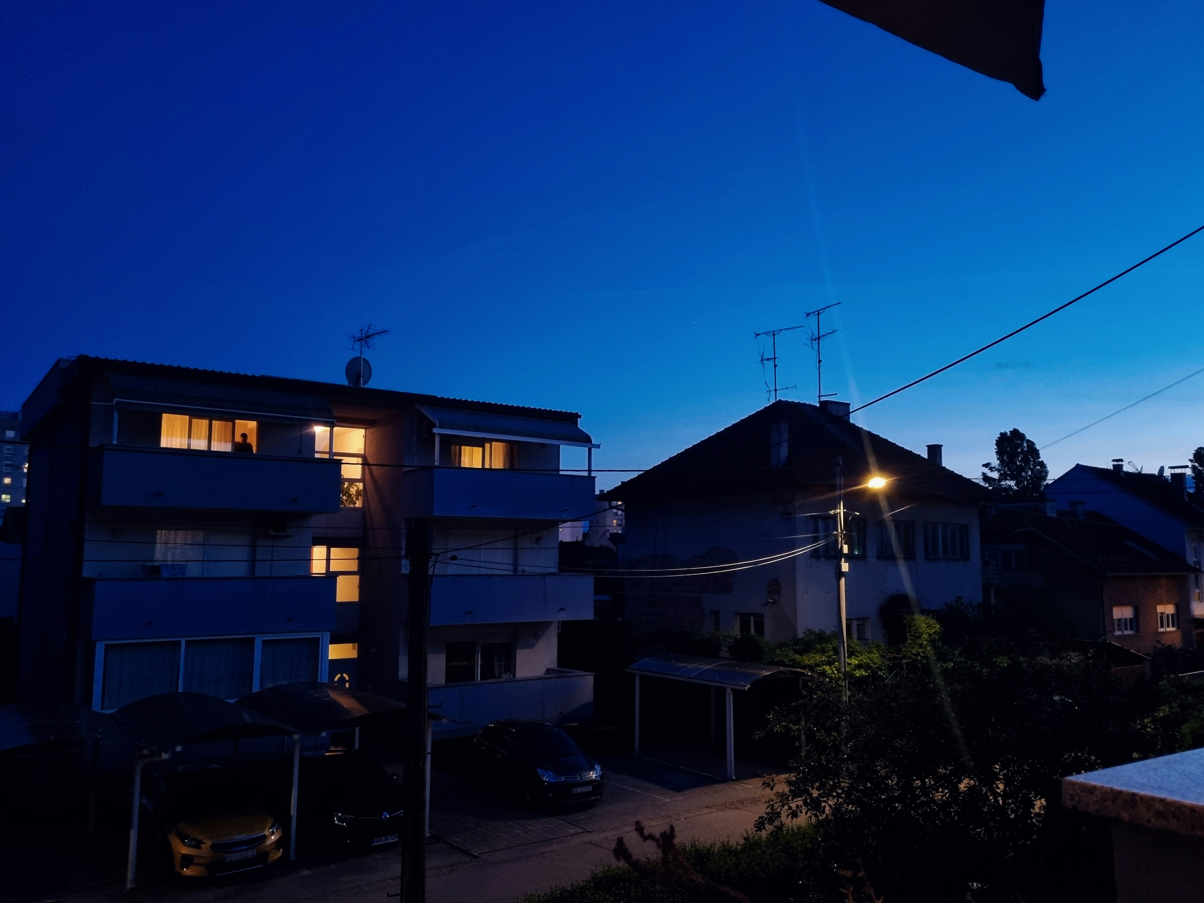 A view of some buildings at night from a balcony
