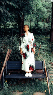 A woman standing on a bench in the woods