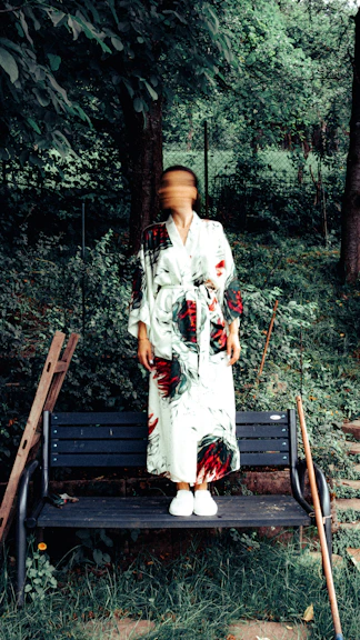 A woman standing on a bench in the woods