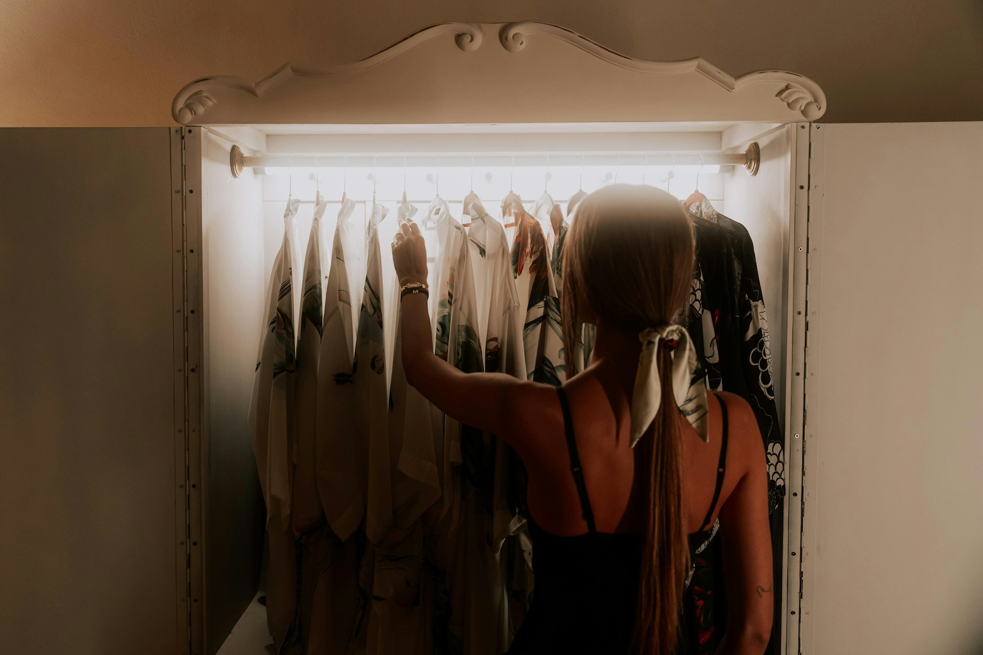 A woman standing in front of a mirror in a closet