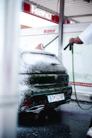 A man is washing a car with a hose