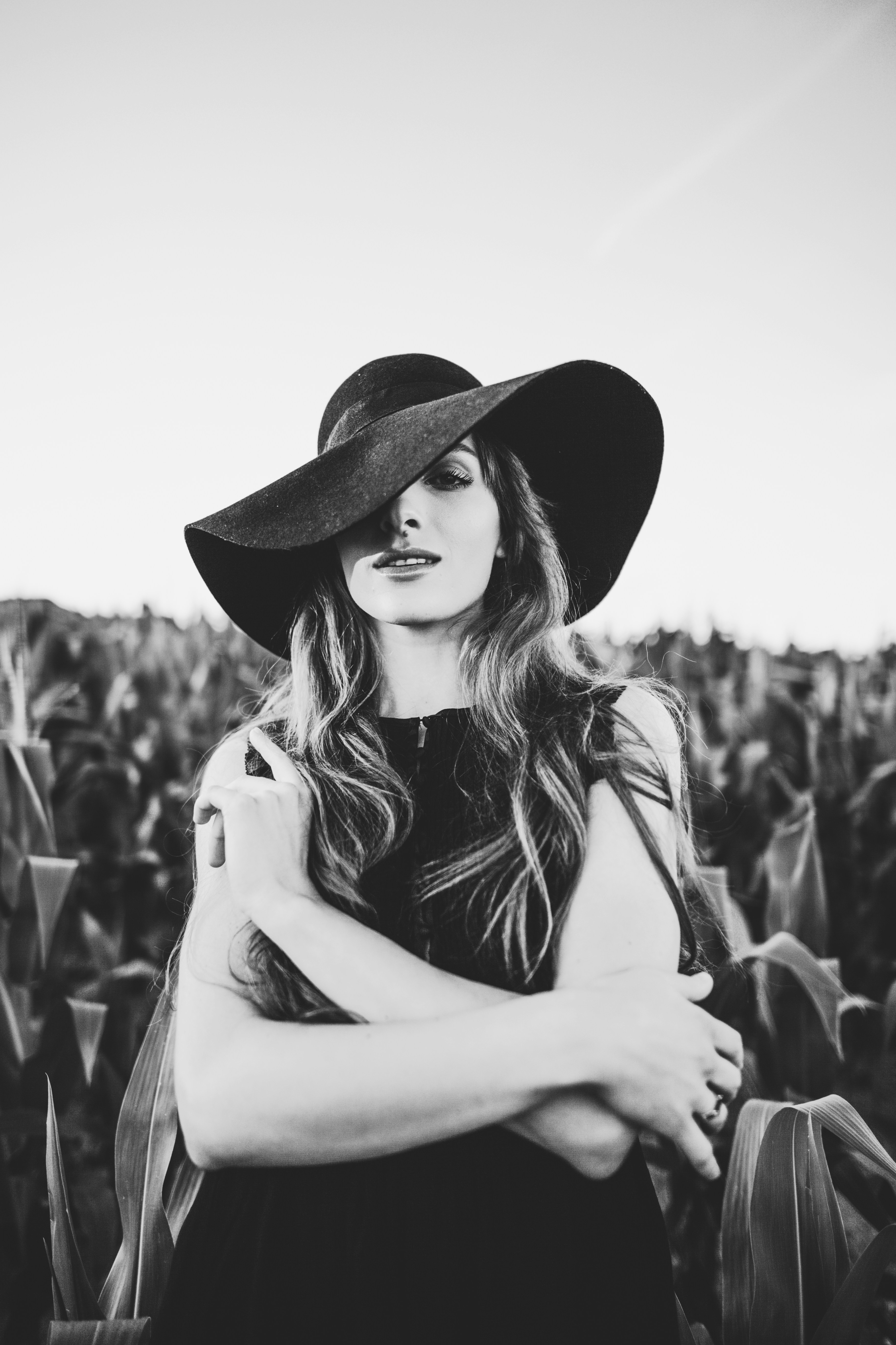 Une femme portant un chapeau debout dans un champ