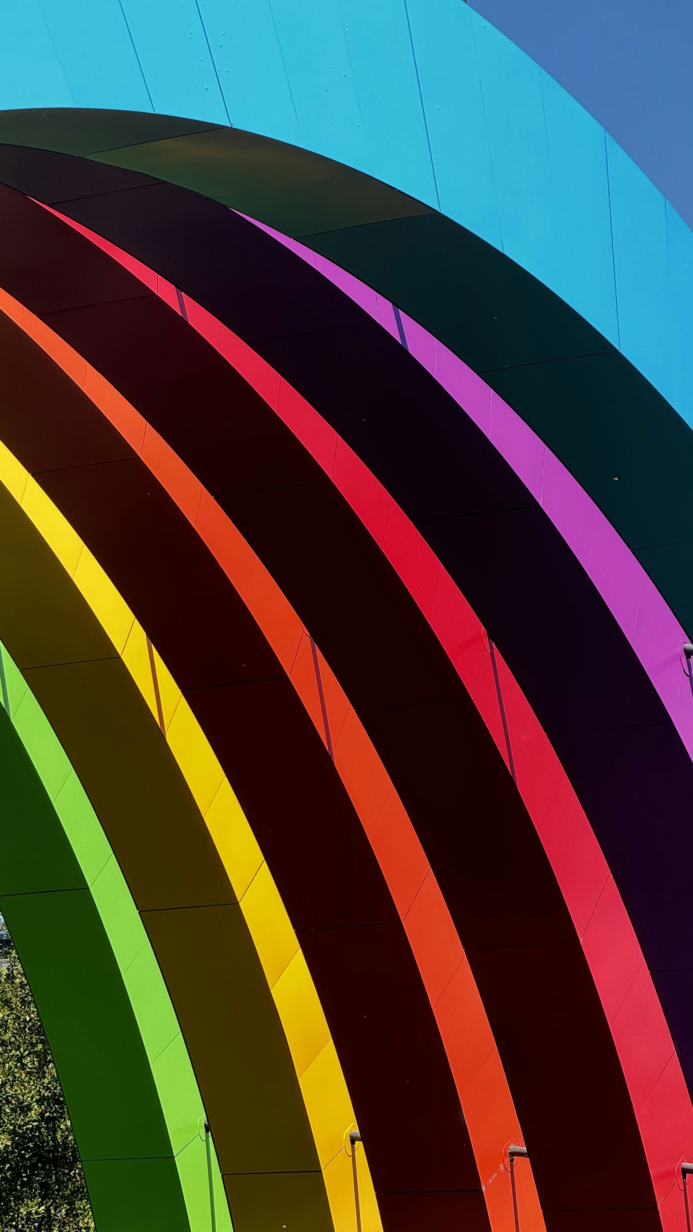 A rainbow colored building with a sky background