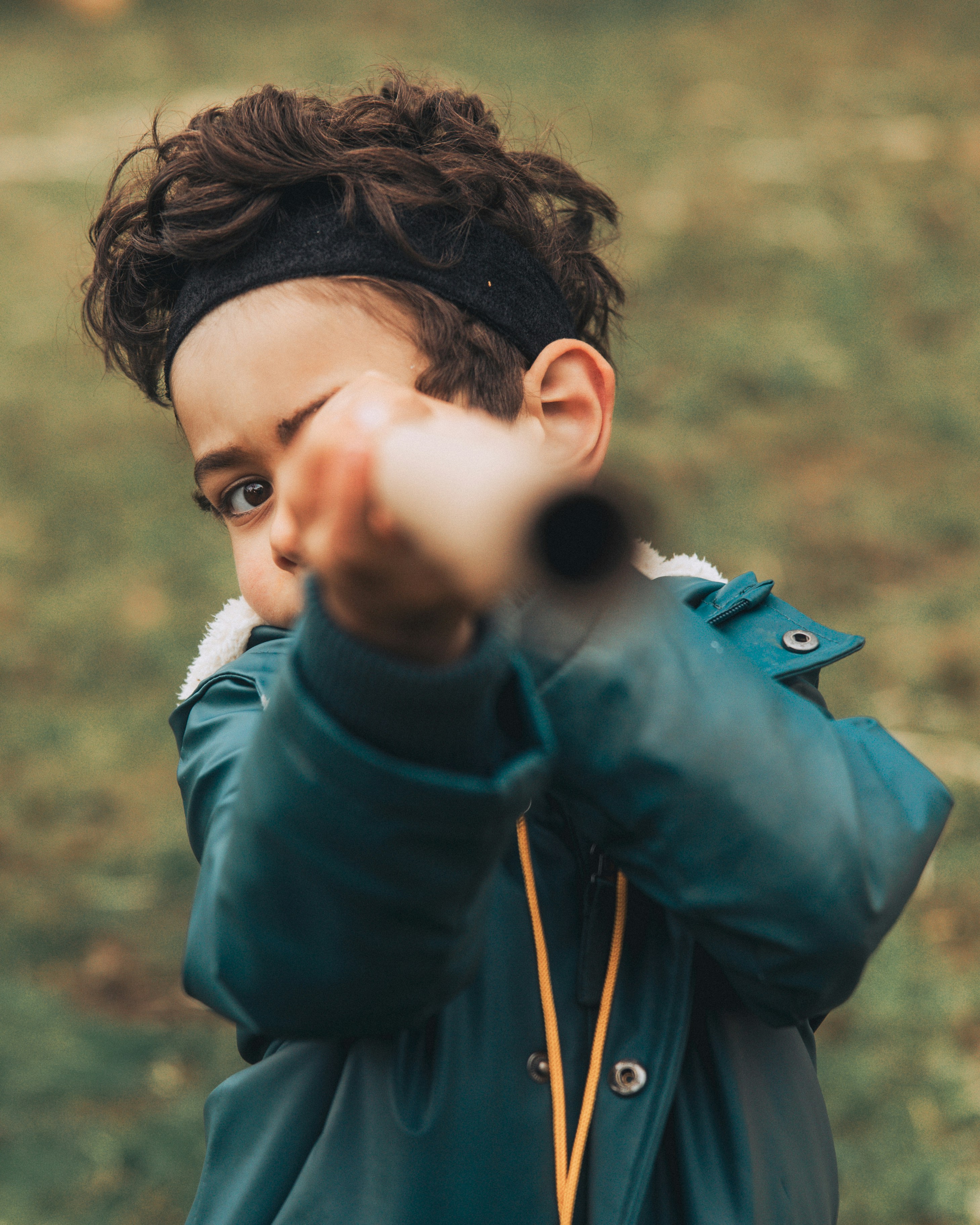 A young boy pointing a gun at the camera