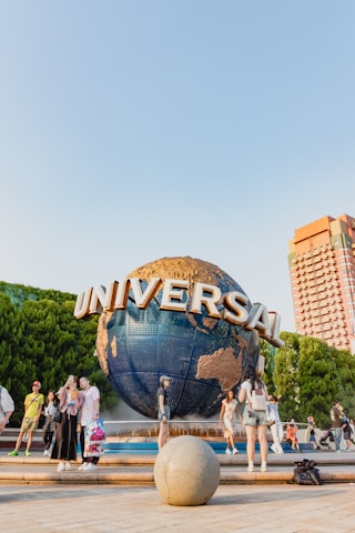 A group of people standing around a giant globe