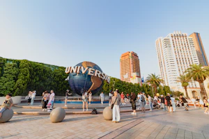 Un grupo de personas de pie frente a la esfera icónica de Universal Studios