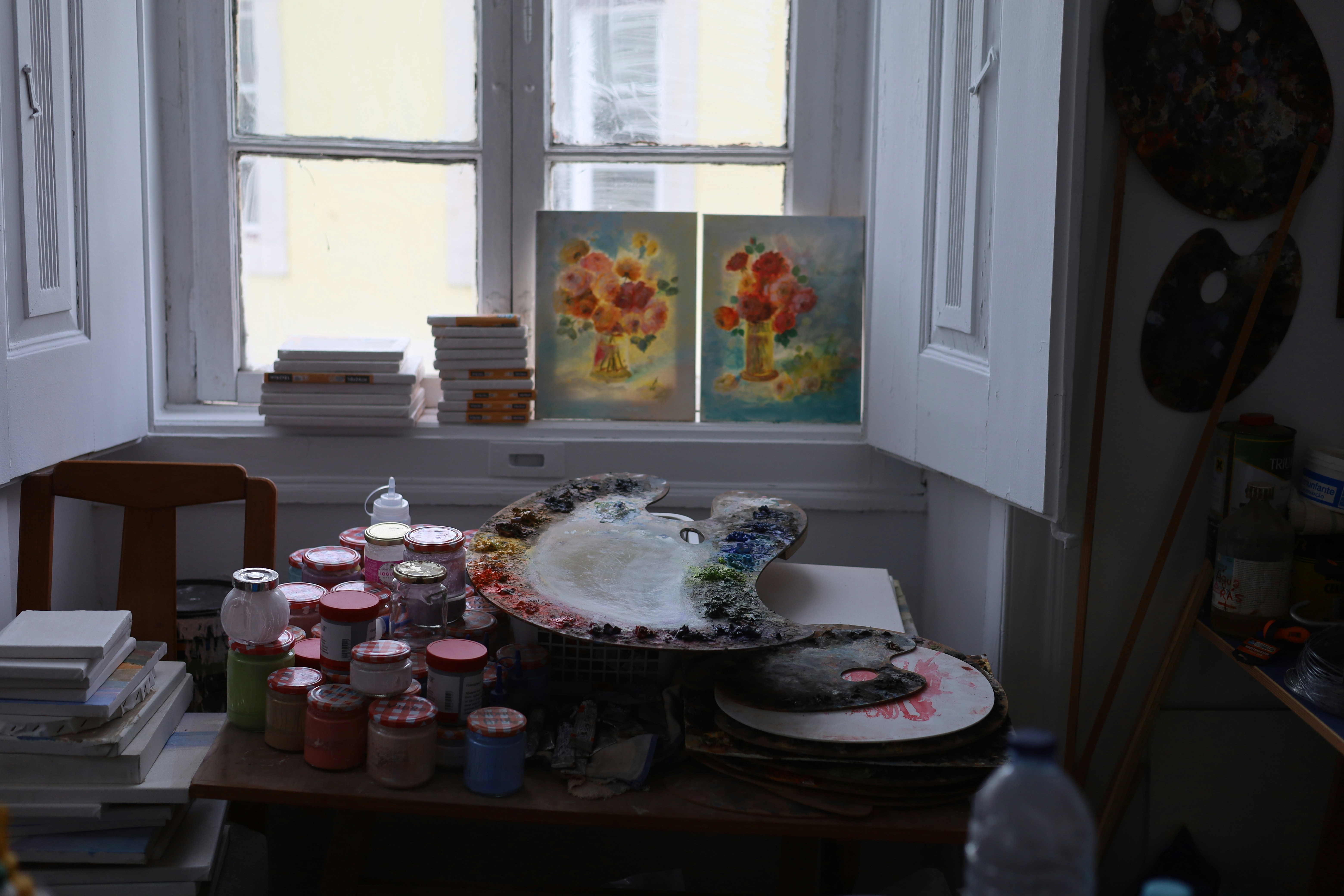 A cluttered table in front of a window