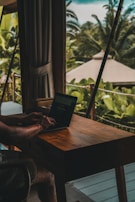 A man sitting at a table using a laptop computer