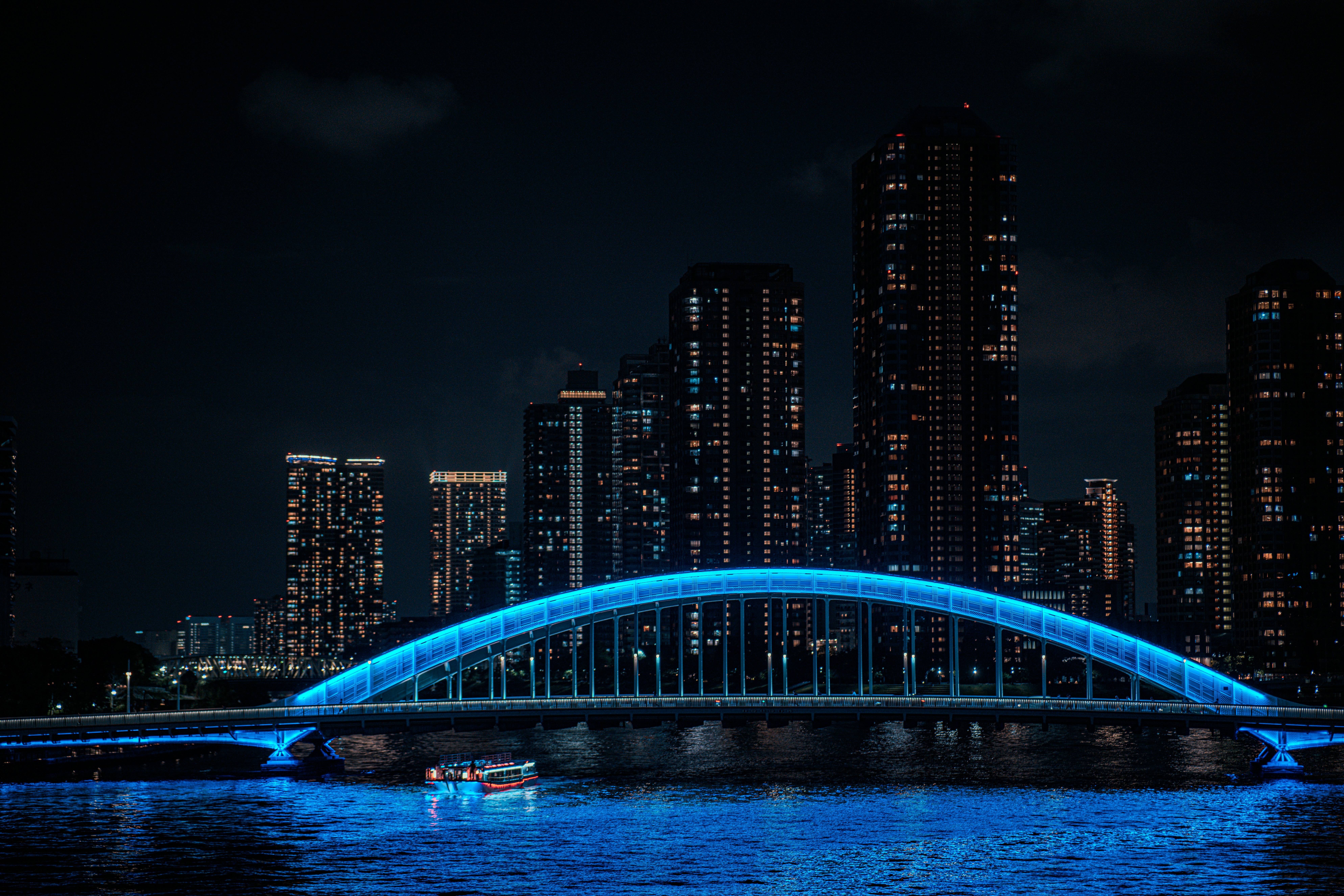 A bridge over a body of water with a city in the background
