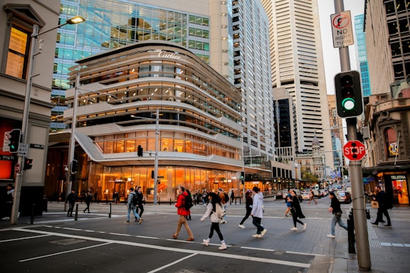 A group of people crossing a street in front of tall buildings