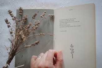 A person holding a book open to a plant