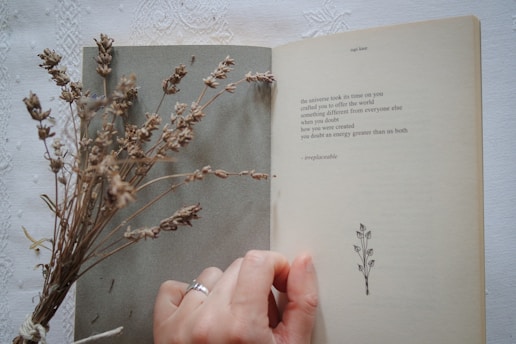 A person holding a book open to a plant