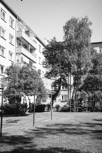 A black and white photo of a tennis court and a building