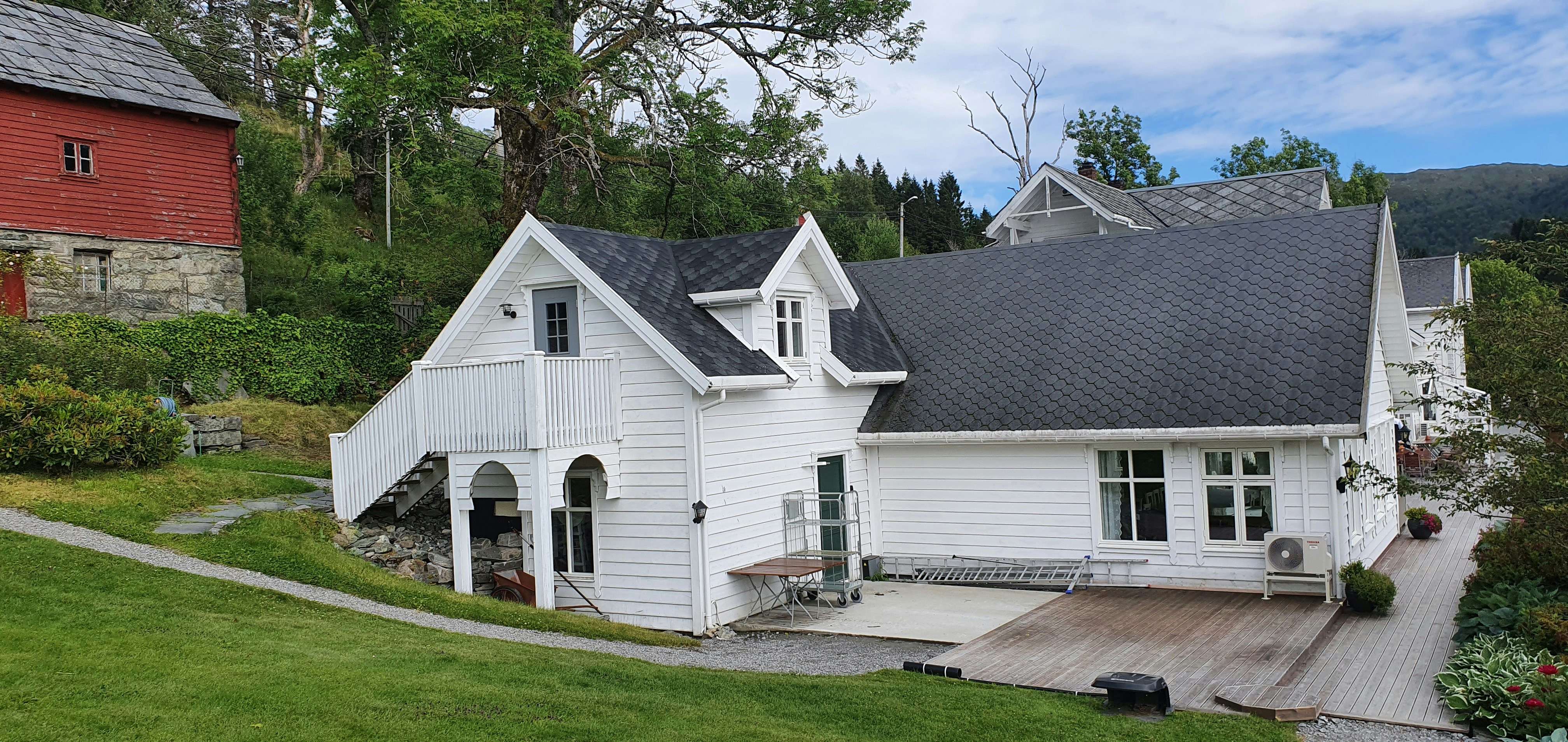 A large white house sitting on top of a lush green hillside