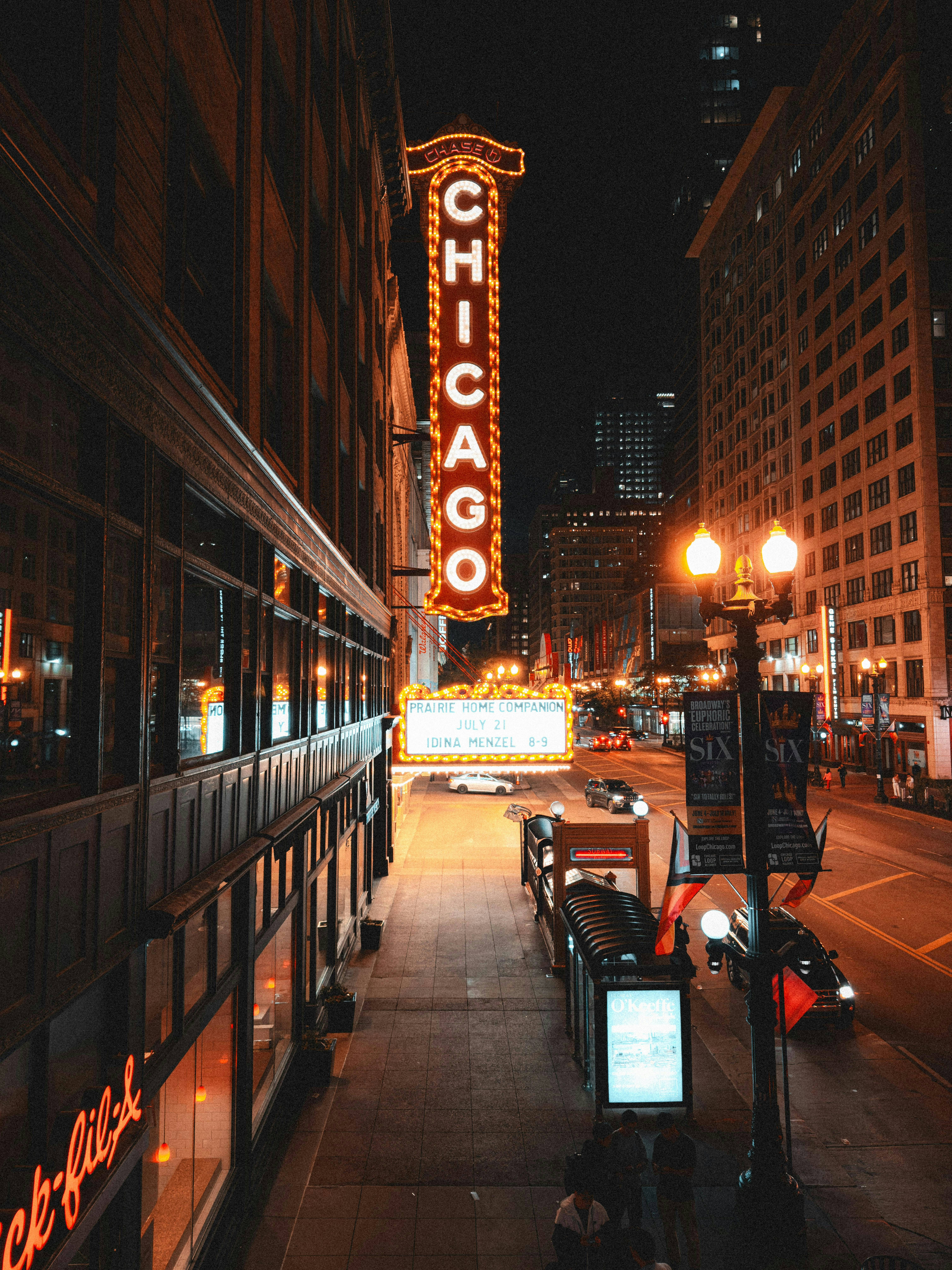 A city street at night with a chicago sign lit up