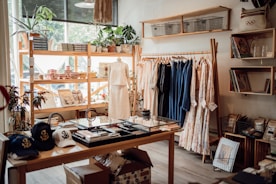 A clothing store with clothes and hats on display