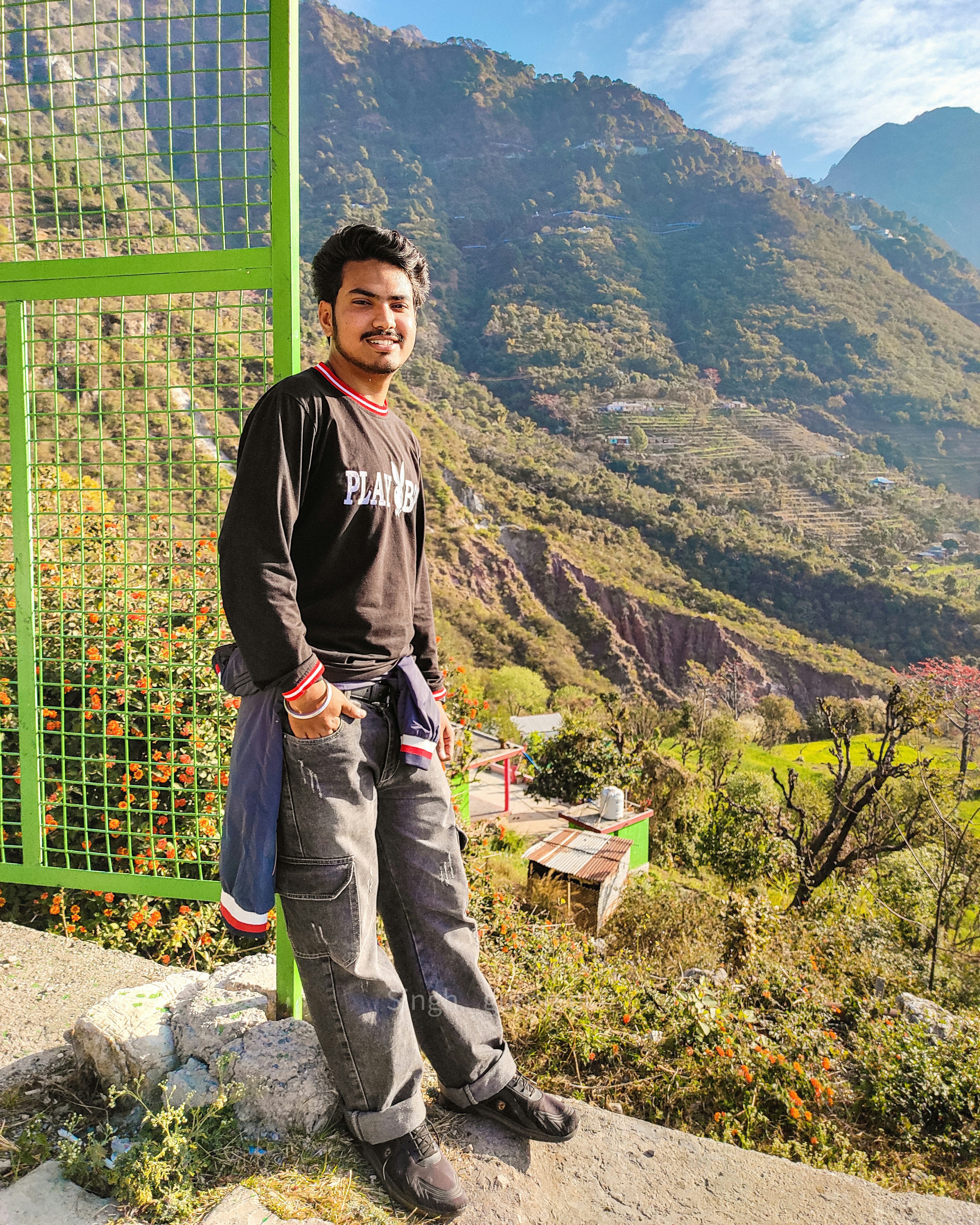 A man standing in front of a green gate