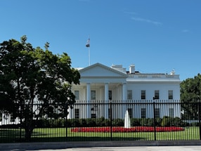 A white house with a black fence in front of it