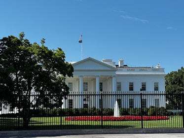 A white house with a black fence in front of it