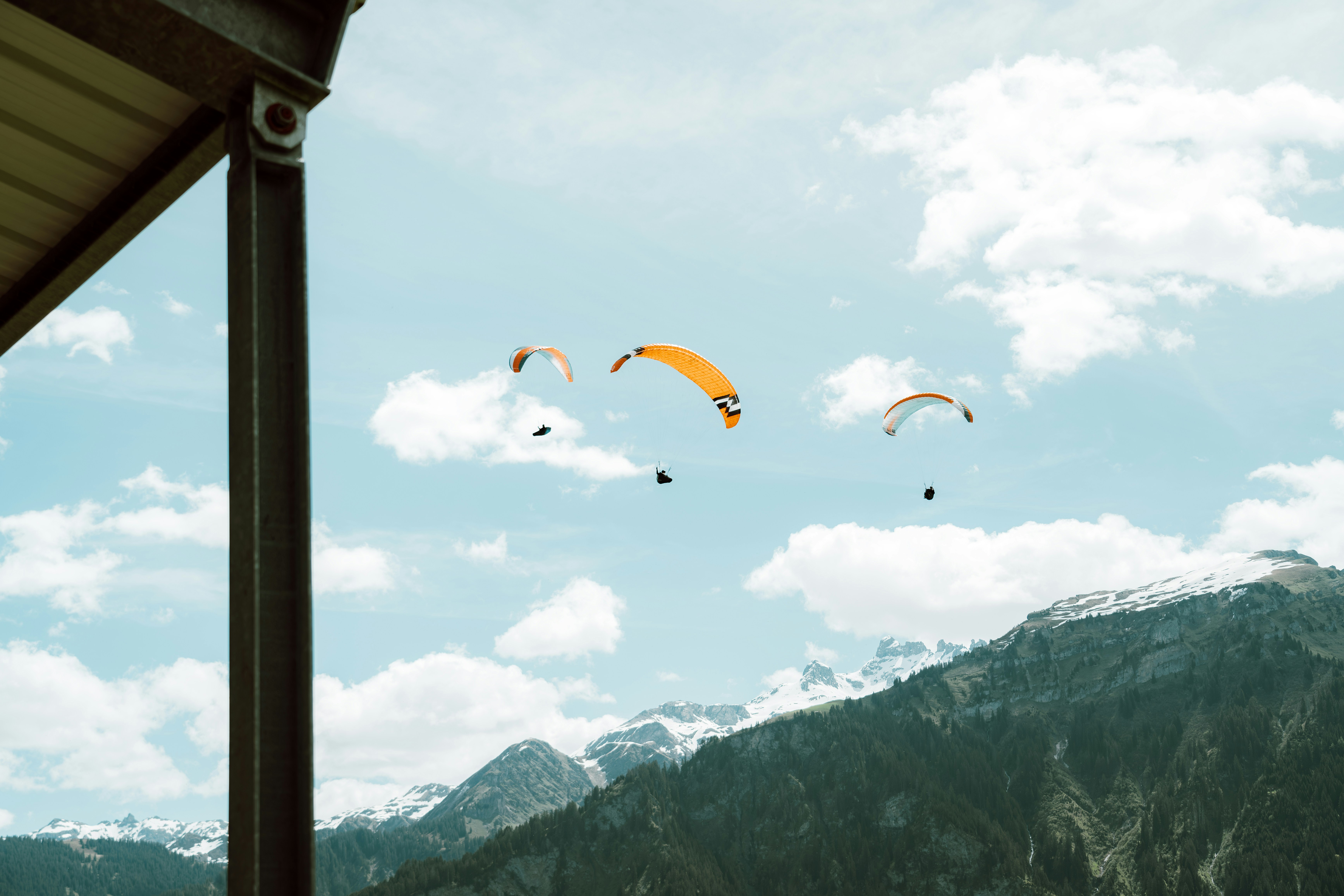 A group of people flying kites over a mountain