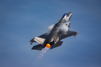 A fighter jet flying through a blue sky