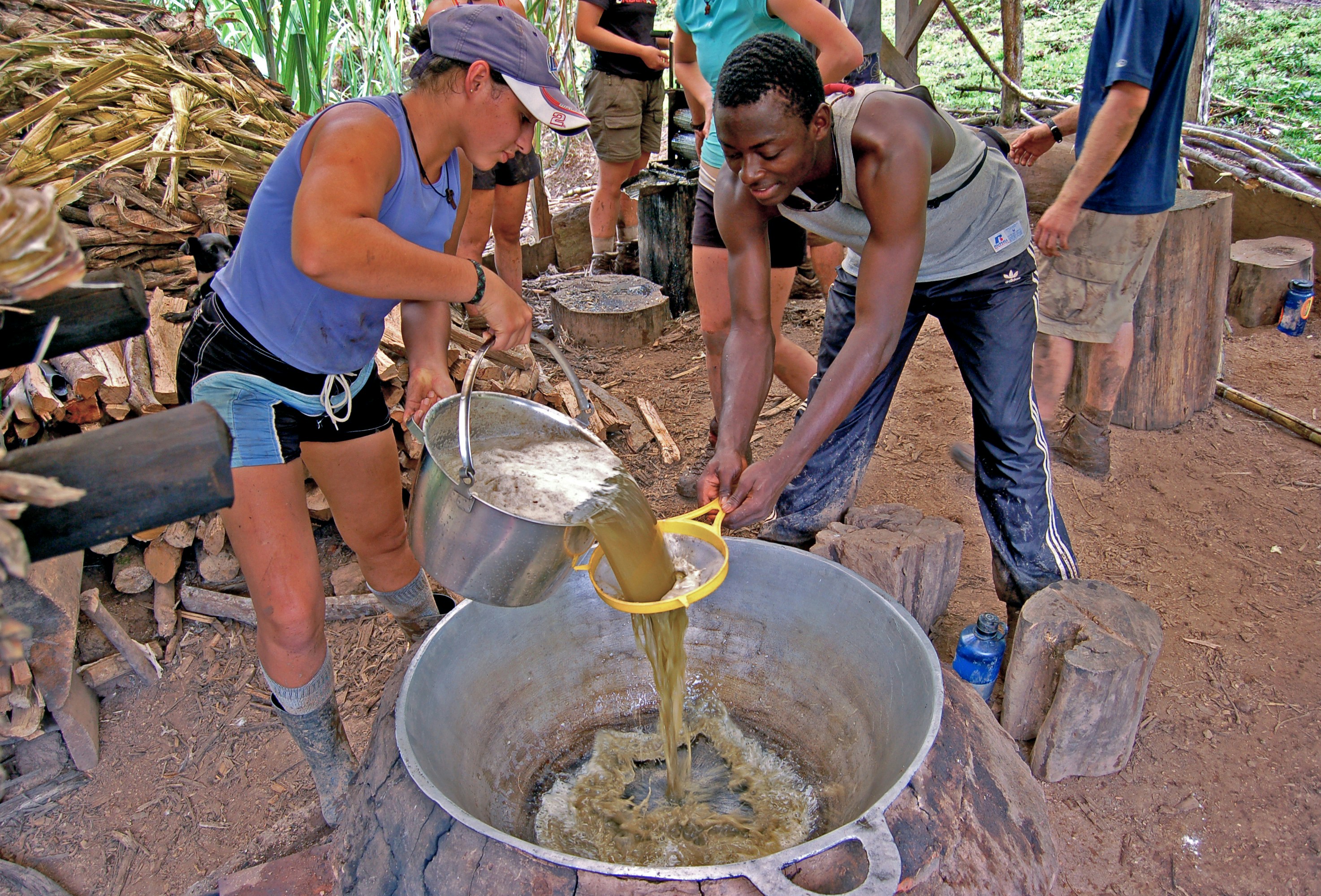 A group of people standing around a metal bowl