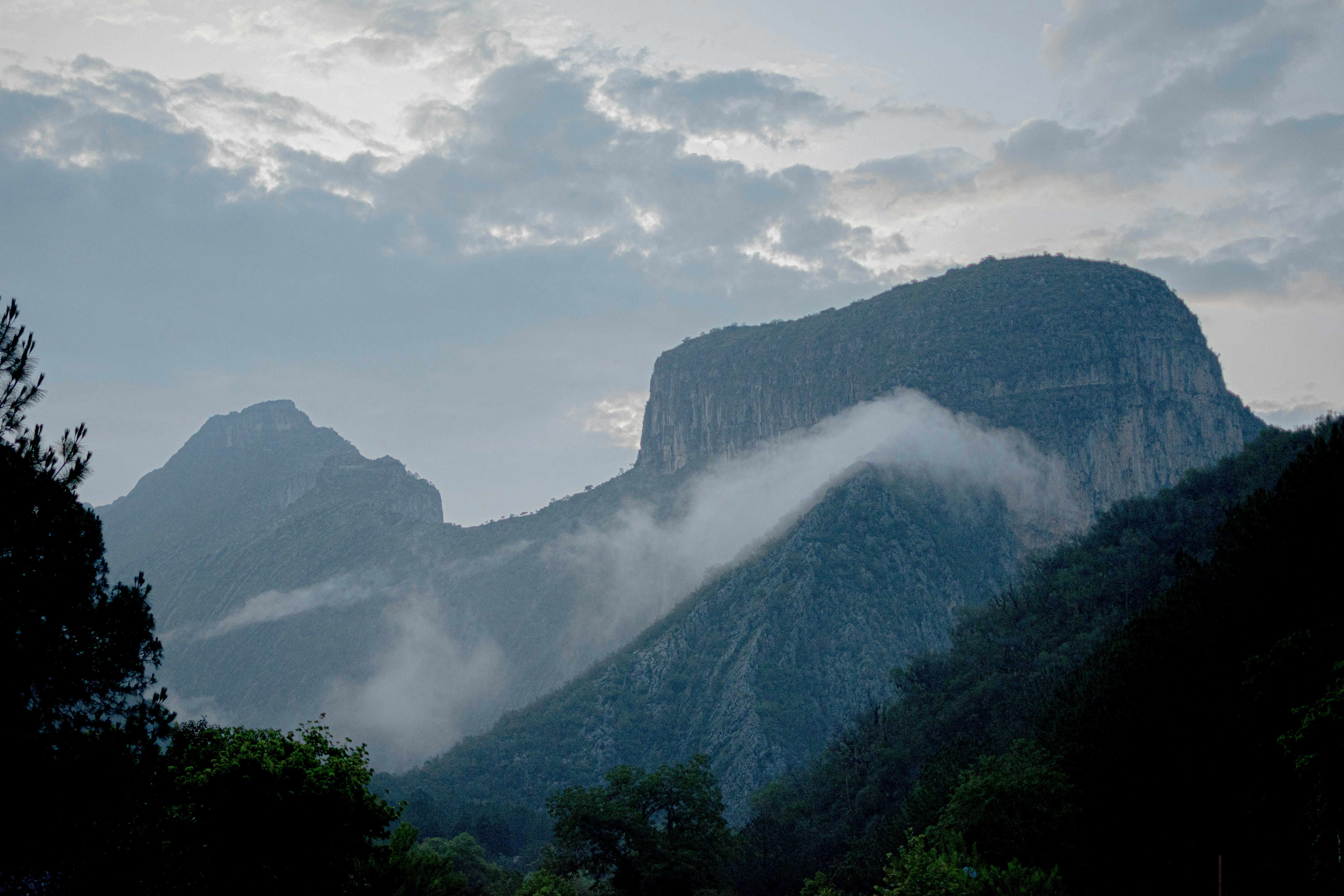 A view of a mountain range with clouds in the sky