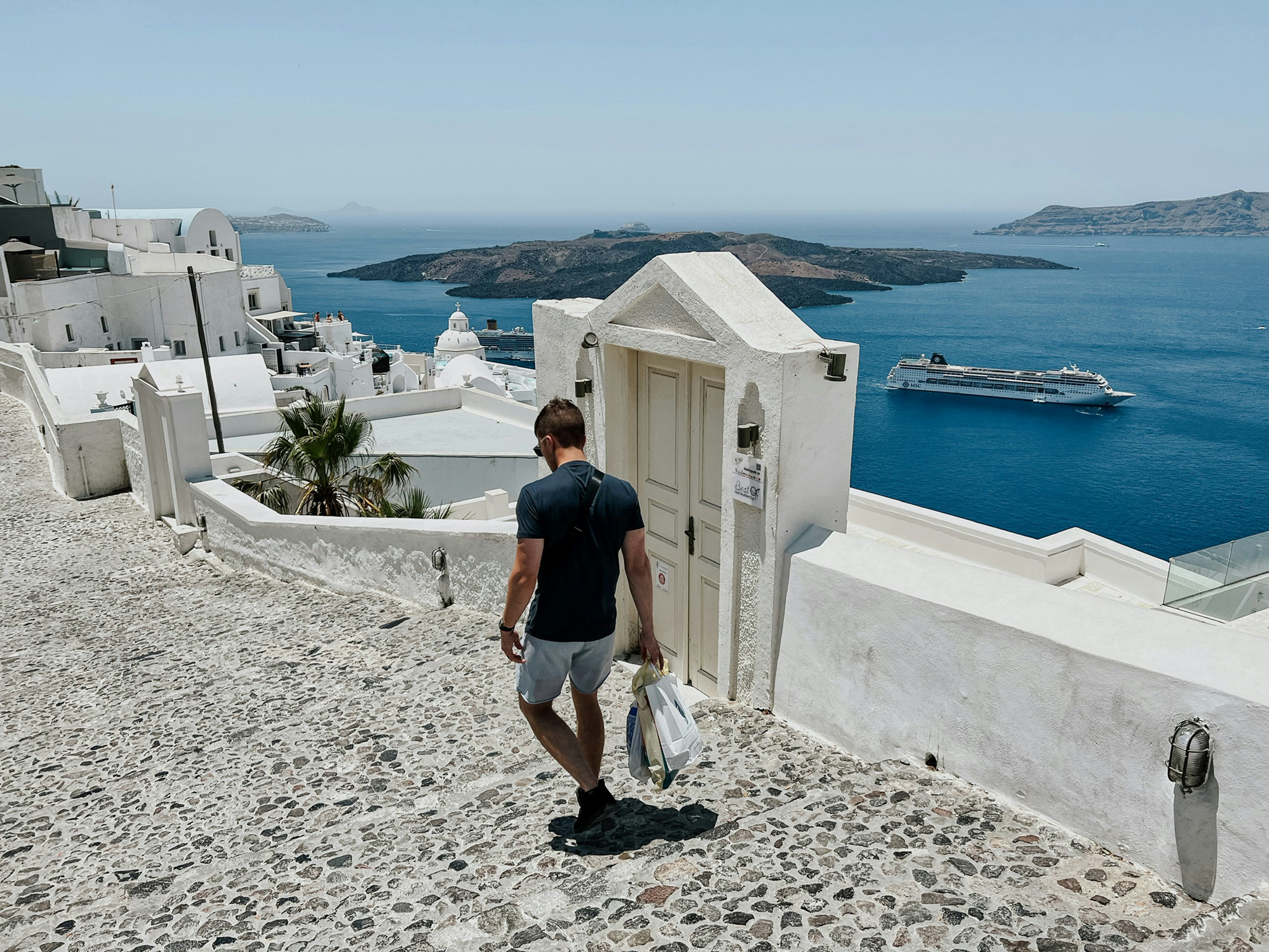 Traveler walking along a Greek coastal path with sea view